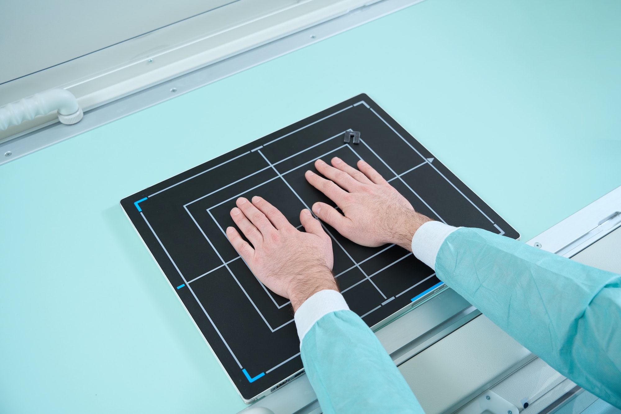 Top view of man putting two hands at the special place during the radiotherapy